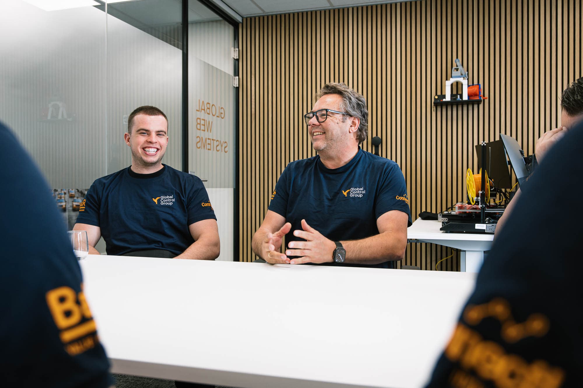 Two GCG engineers talking at a meeting table.