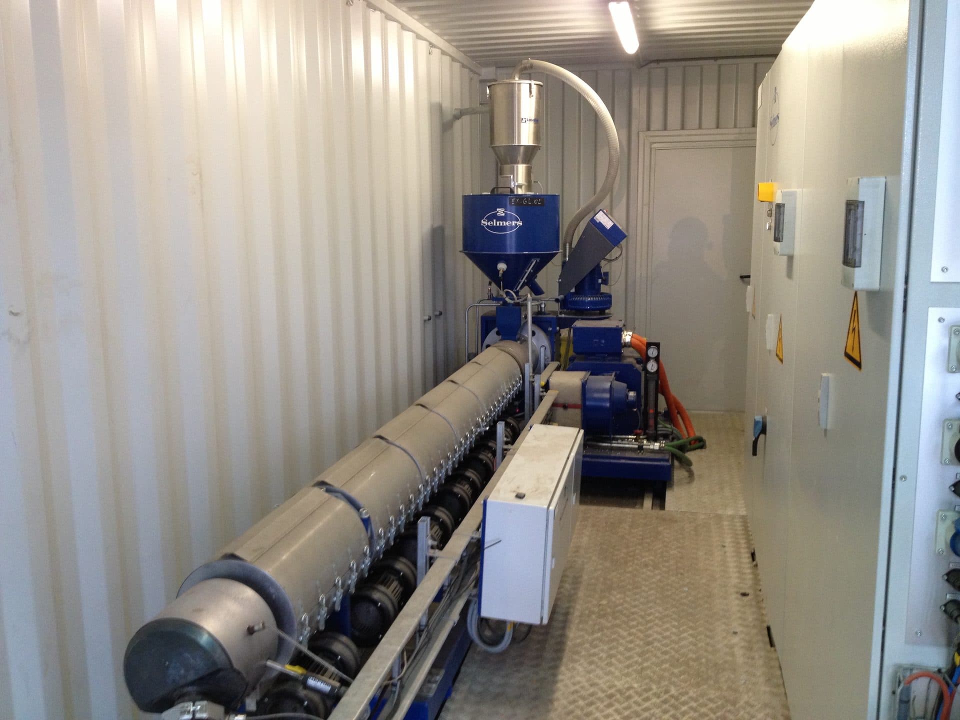 Extruder with feed hopper in an installation container.