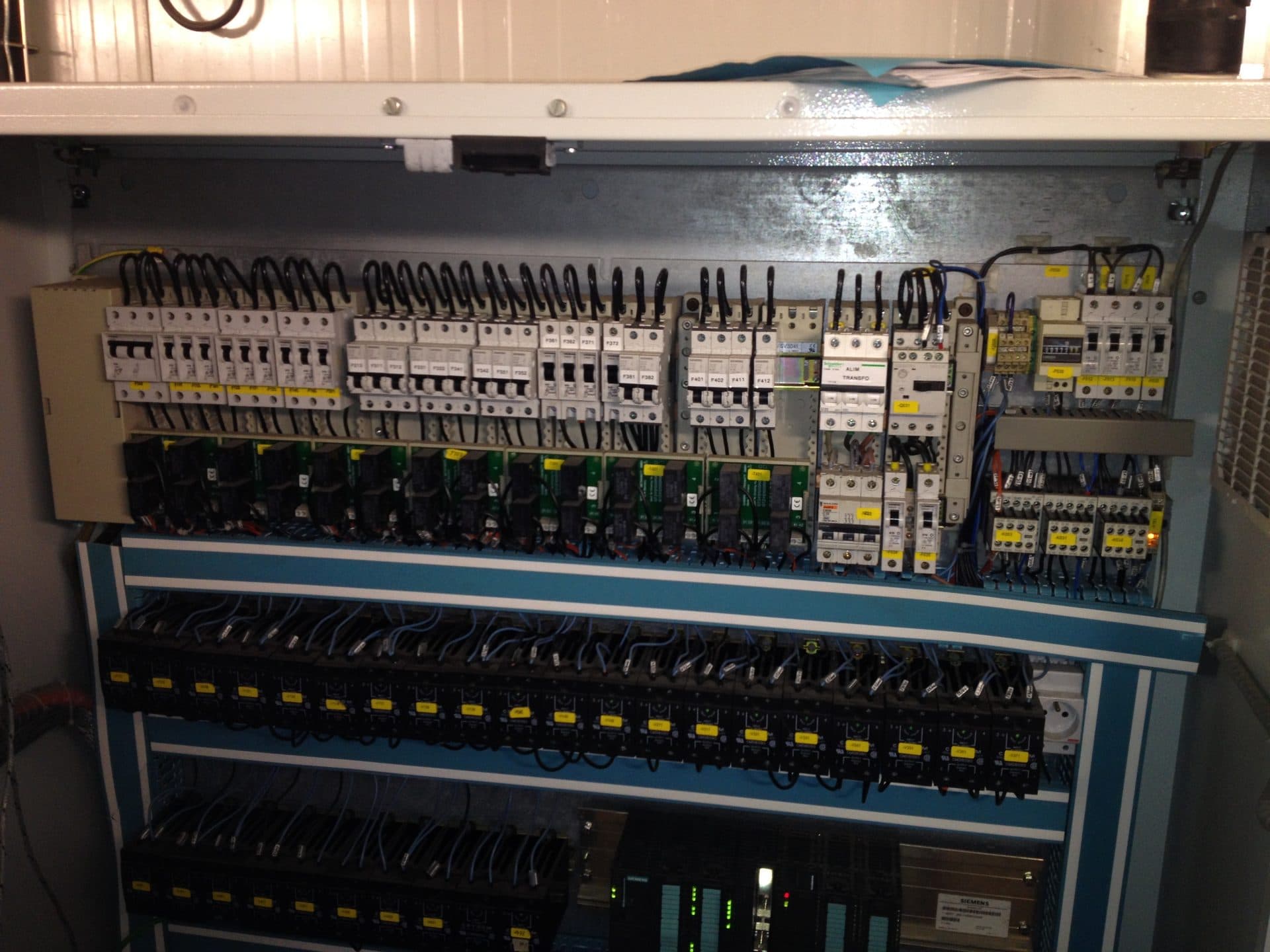 Control cabinet with breakers, relays and a PLC in a process plant.